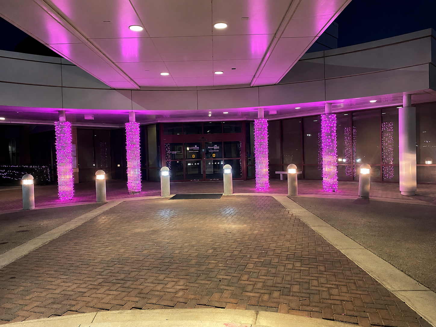 Venue entrance columns wrapped in pink lights for a breast cancer awareness event