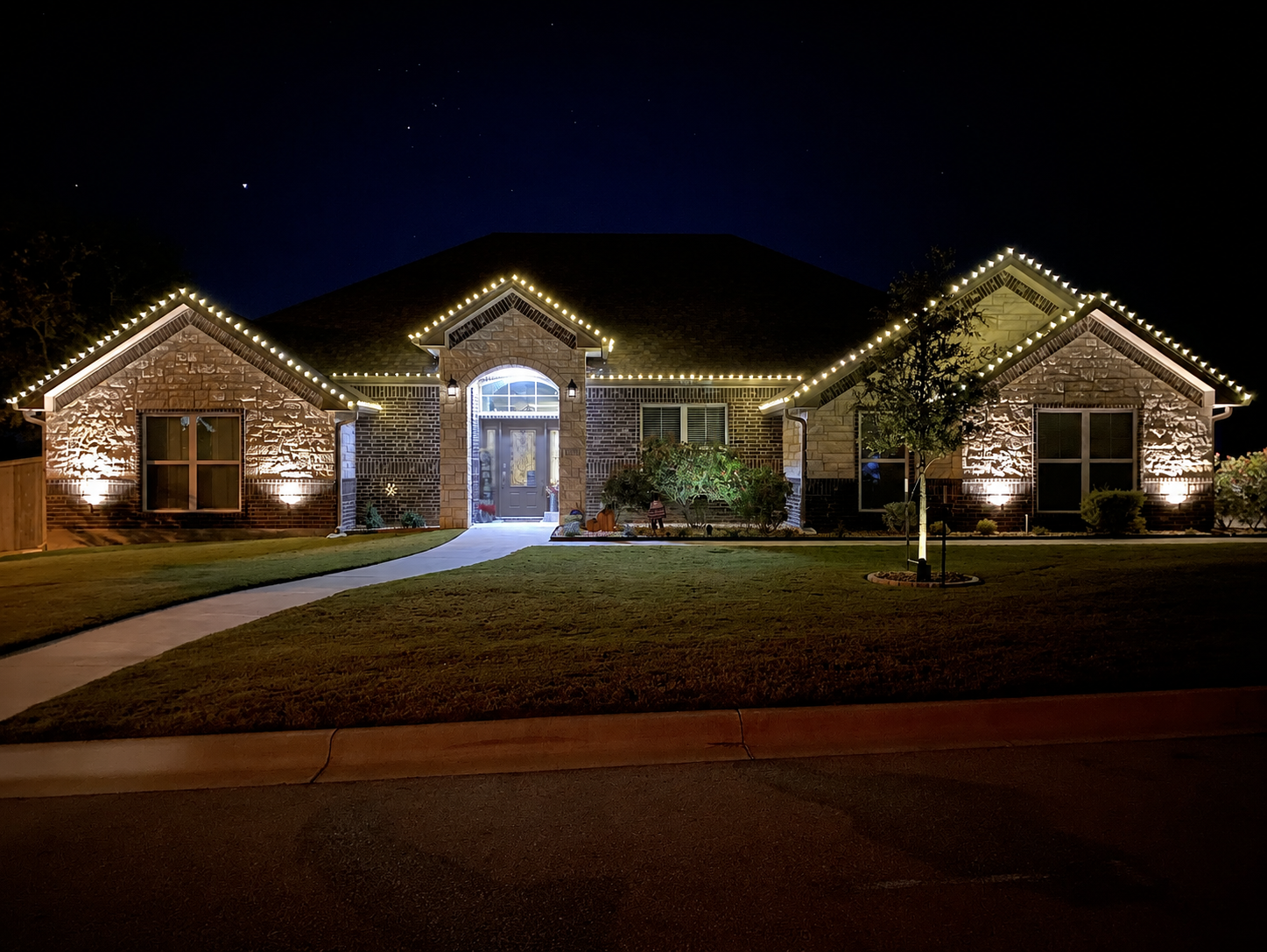 Classic warm-white roofline lighting on a completed home