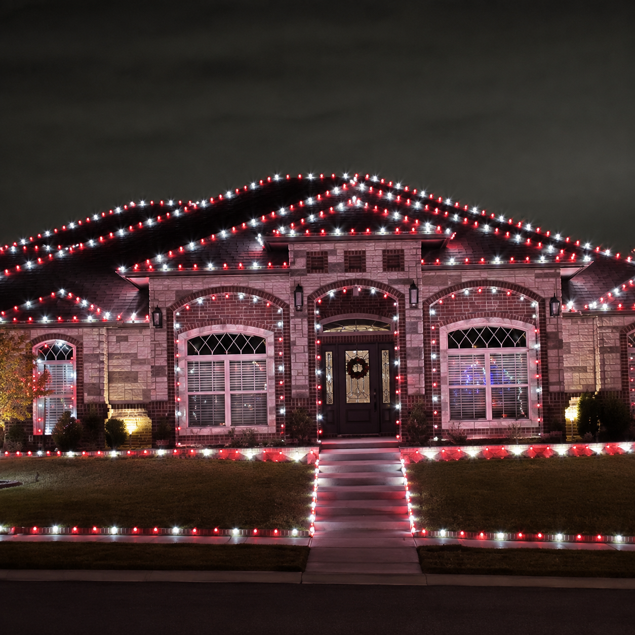 Featured home decorated in red and white lights by Jason's Holiday Lighting