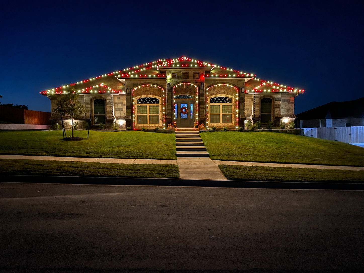The same featured home in warm white and red Gingerbread lighting