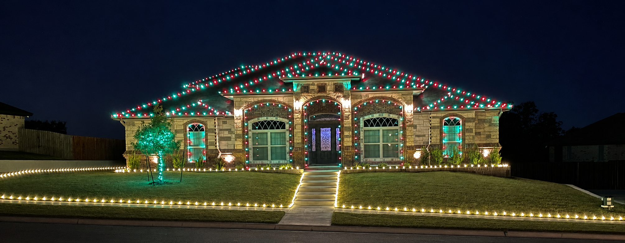 The same featured home illuminated in red and green lights