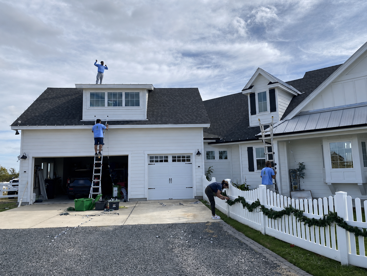 Jason's Holiday Lighting crew installing roofline lights and garland
