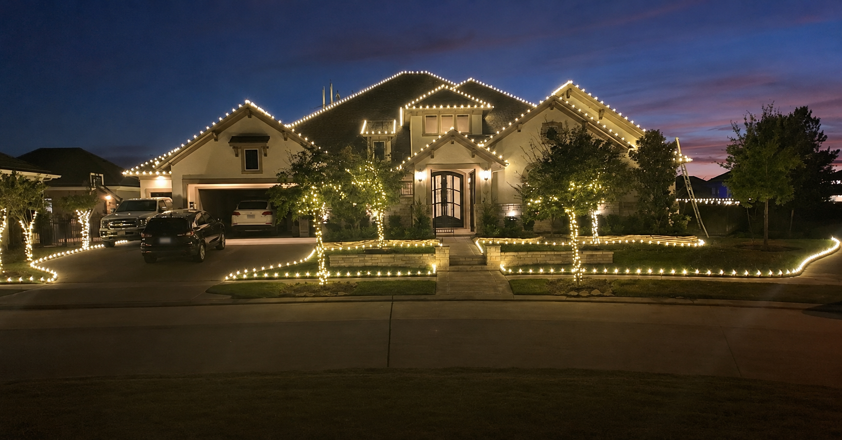 Warm-white holiday lights installed along the roofline and roof ridges